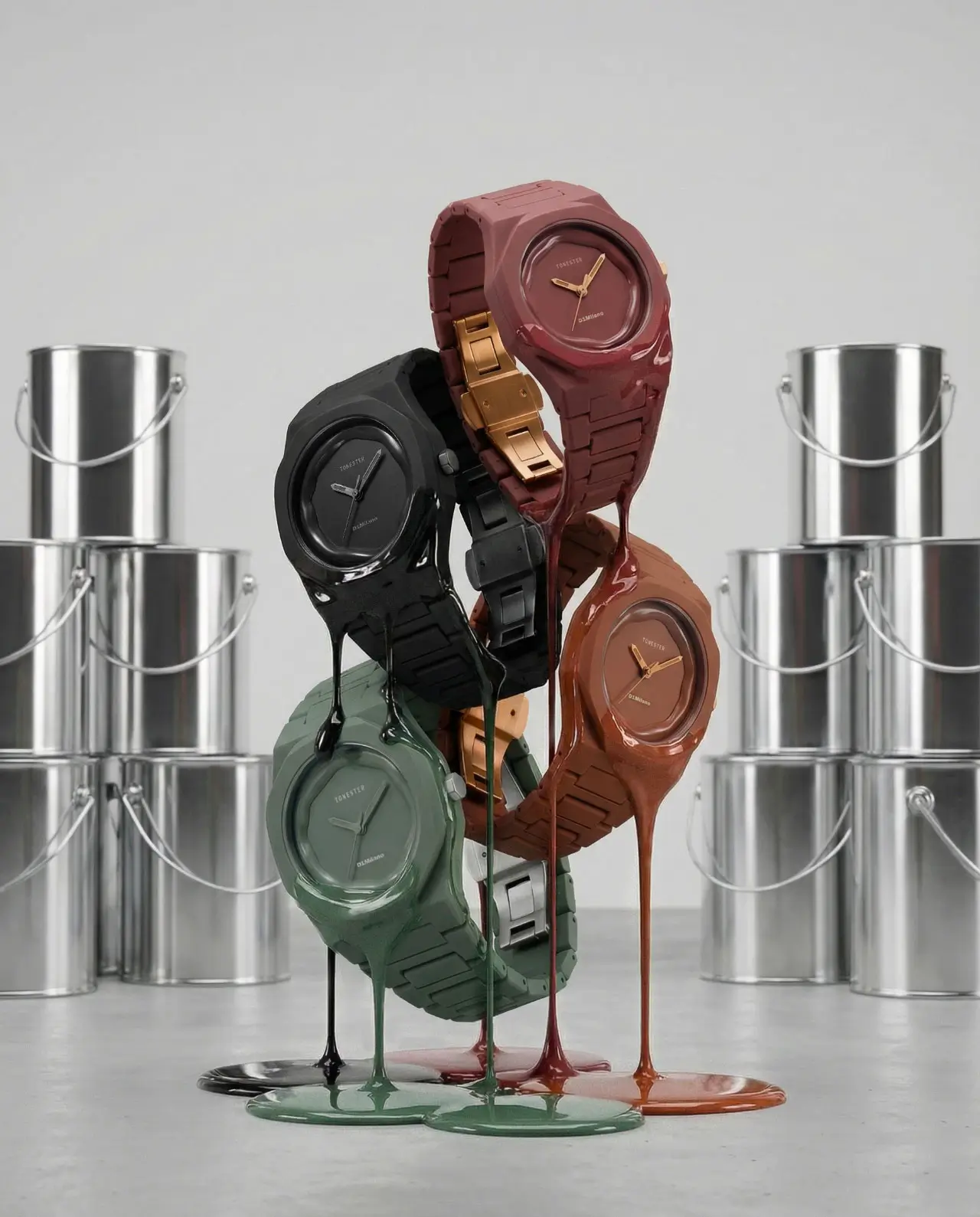 Studio product shot of multiple wristwatches stacked together, each coated in glossy, dripping paint in tones of black, green, and earthy browns, creating a sculptural effect. The watches feature minimalist dials and integrated bracelets, with gold accents visible on one piece, while a backdrop of neatly stacked metal paint cans reinforces the industrial, art-meets-design concept