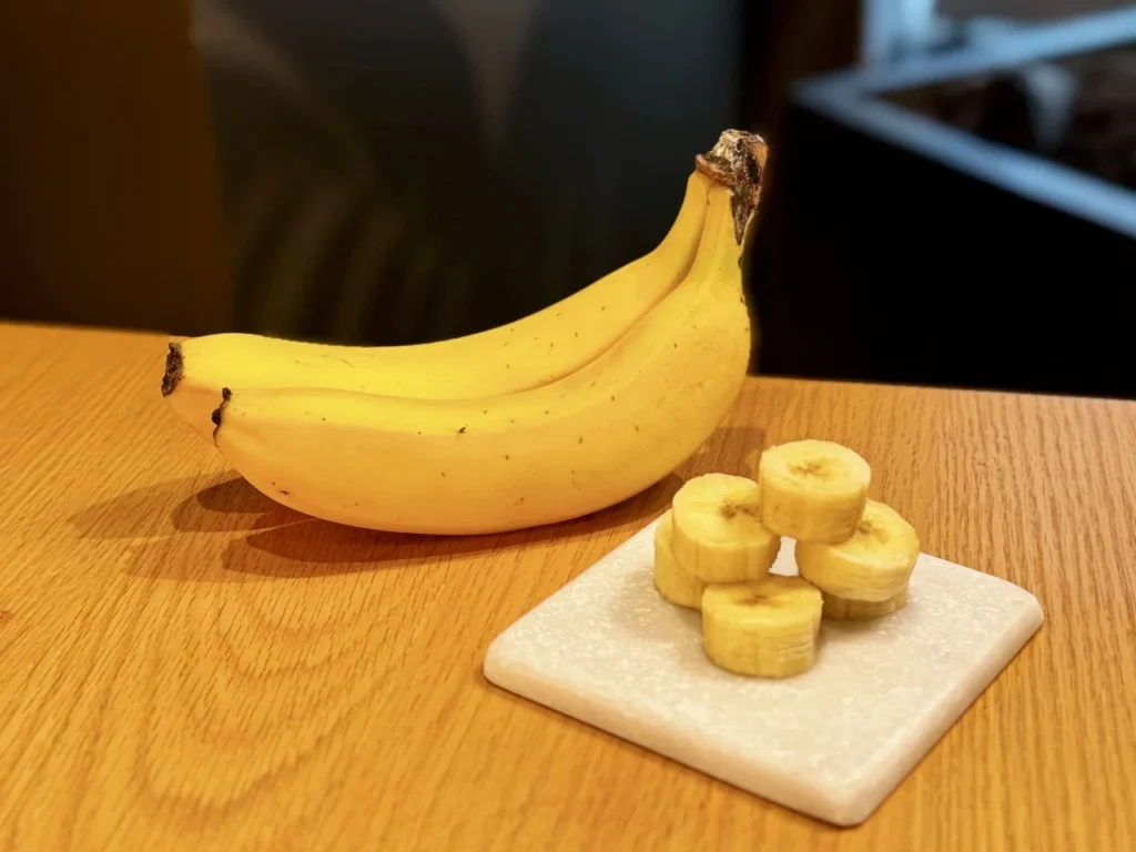 Fresh whole bananas and sliced banana pieces arranged on a tabletop to highlight the fruit used in Starbucks Japan’s Banana Affogato Frappuccino