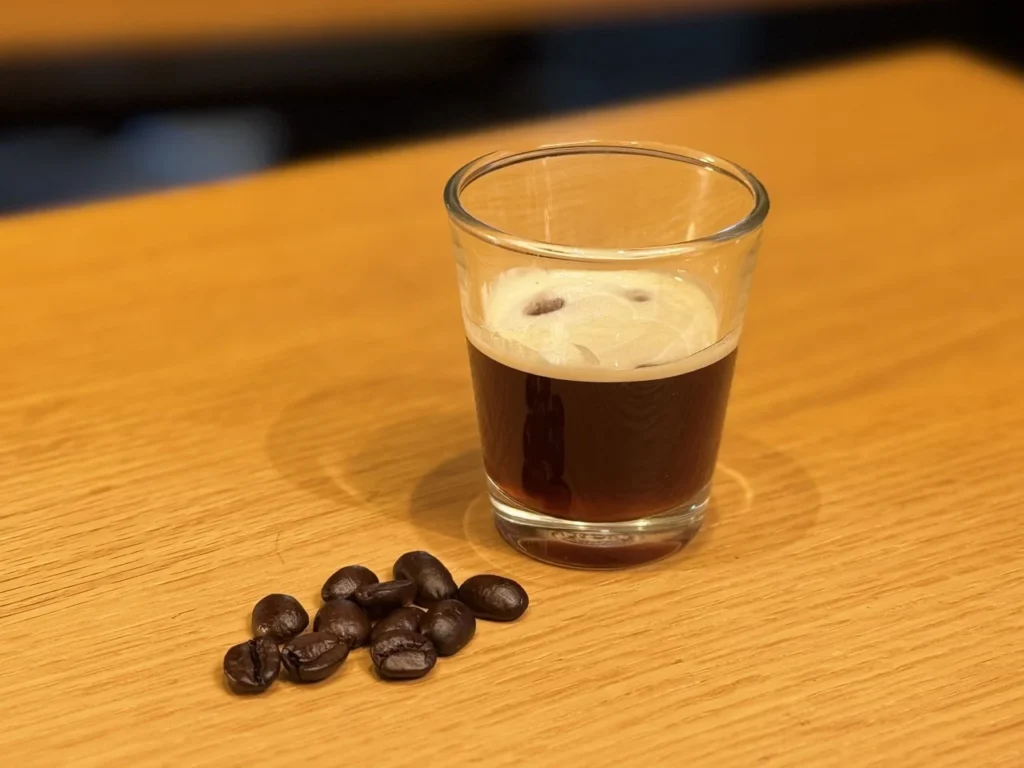 Freshly pulled espresso shot beside roasted coffee beans, emphasizing the affogato-style coffee element of Starbucks Japan’s seasonal beverage