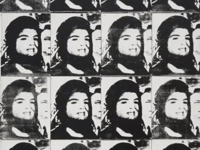 A monochromatic repeated portrait composition arranged in a rigid 4x4 grid, echoing the serial visual language of mid-century Pop Art and underground print culture. The same grainy photographic image is reproduced sixteen times with subtle shifts in contrast, fading, and ink saturation, creating the appearance of distressed silkscreen transfers or photocopied newspaper halftones. The long-haired, bearded subject remains centered throughout, his calm expression rendered almost icon-like through repetition, while a partially obscured secondary face lingers behind him in each frame, adding tension and spectral depth. The rough textures, uneven printing artifacts, and black-and-white tonal palette evoke archival media reproduction, recalling Andy Warhol’s mechanically repeated portrait works from the 1960s. Each panel appears slightly degraded, as though duplicated through successive generations of print transfer, reinforcing themes of memory erosion, celebrity image-making, and collective visual consumption. The composition exists between fine art and protest-poster aesthetics, balancing Pop Art seriality with the raw immediacy of DIY zine culture and photocopied street graphics