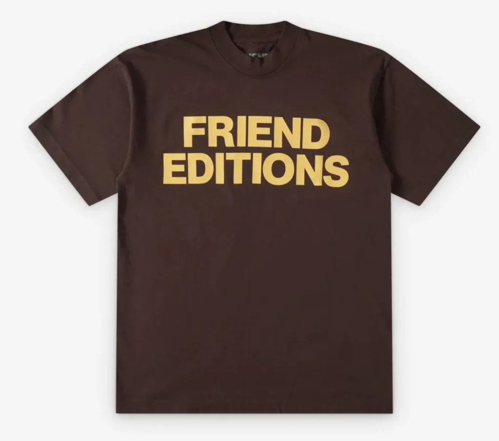 Brown Friend Editions logo T-shirt featuring oversized gold block-letter typography across the chest with a minimalist short-sleeve streetwear silhouette against a clean studio background