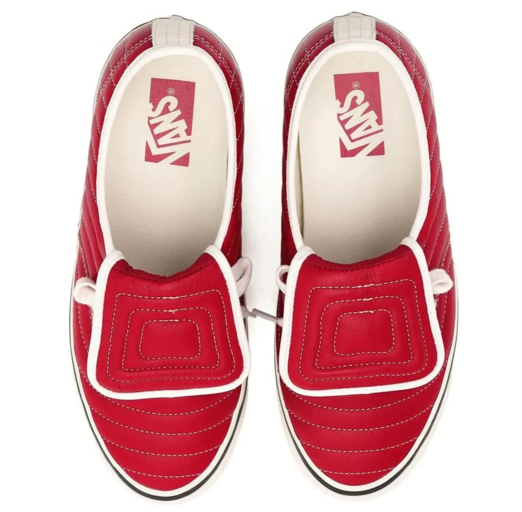 Top-down view of a pair of red quilted Vans slip-inspired lace shoe featuring oversized padded tongue flaps, cream interiors, contrast stitching, and minimal vintage branding