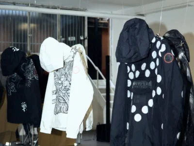 Suspended Napapijri ANORAK REFORGED outerwear installations displayed in an industrial gallery setting, featuring graphic prints, oversized hoods, and sculptural reinterpretations during Milan Design Week 2026