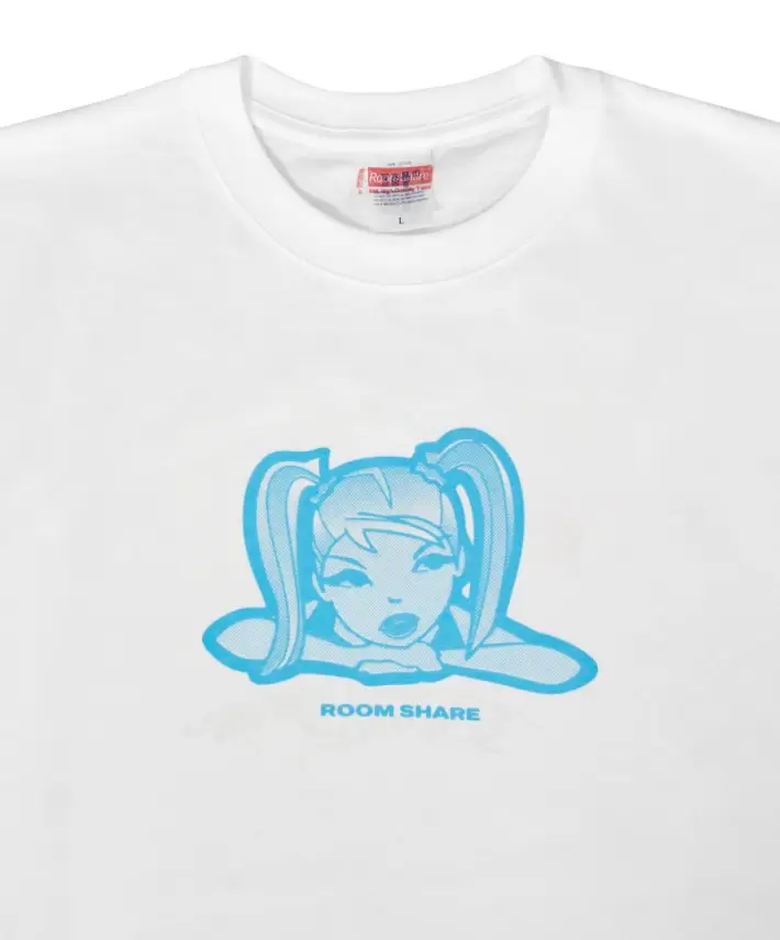 Close-up of a white graphic T-shirt with a minimal light-blue anime character illustration across the chest. The design shows a girl with twin ponytails leaning forward above clean “ROOM SHARE” typography for a softer, early-2000s internet aesthetic