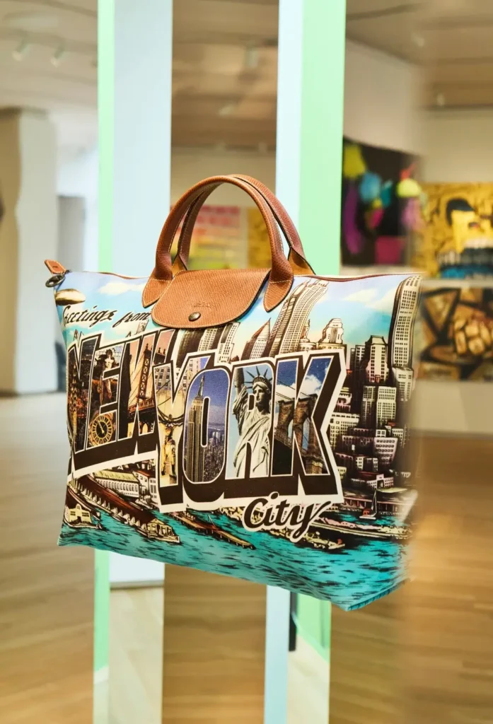 Close-up of the “Greetings from New York” Longchamp Le Pliage tote featuring postcard-style artwork of New York landmarks and skyline imagery