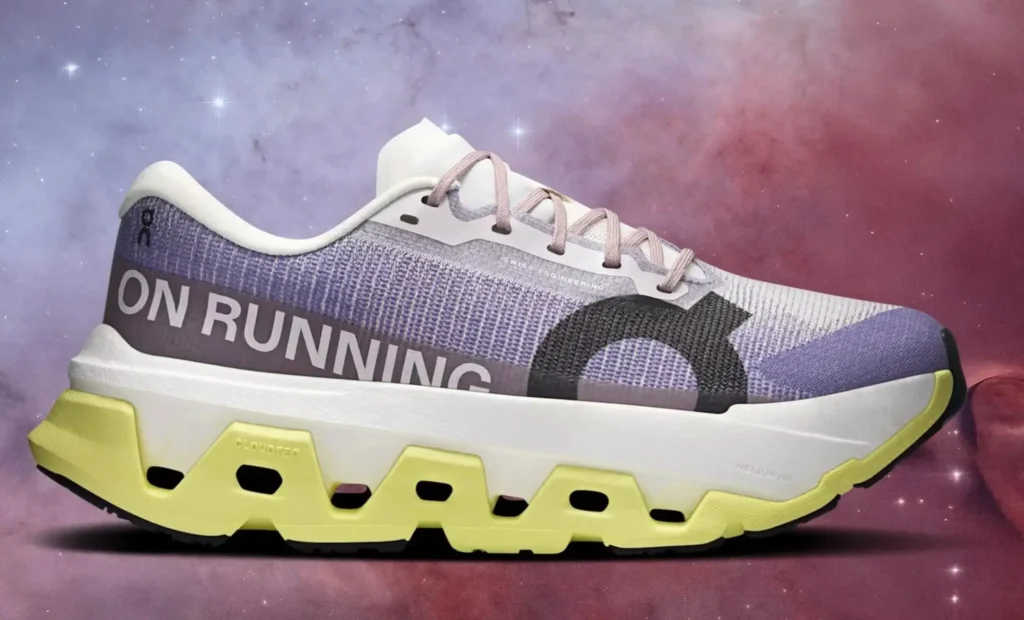 On Running shoe featuring a breathable mesh upper with “ON RUNNING” branding, lace-up construction, and a cushioned sole with yellow CloudTec elements, set against a stylized cosmic gradient background