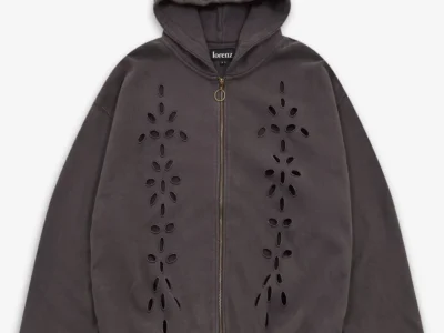 Lorenz Studio Broderie Hoodie in washed black featuring symmetrical floral cutwork embroidery panels, full zip-front closure, oversized hood, and a softly faded garment-washed finish against a neutral background