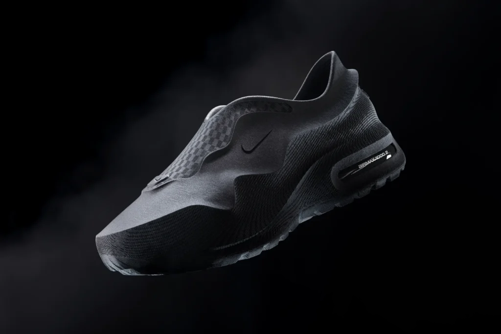 Futuristic all-black Nike slip-on shoe with sculpted molded upper and visible Air Max heel unit floating against a dark atmospheric background