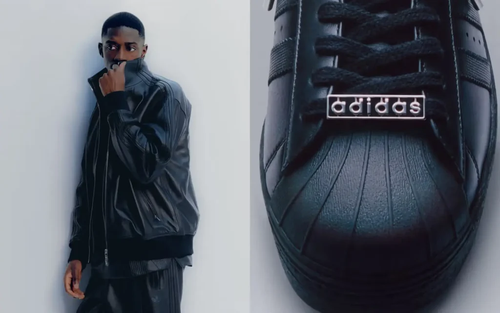 Split-frame campaign image for the adidas A-TYPE collection featuring a model dressed in the black leather Firebird tracksuit beside an enlarged close-up of the A-TYPE Superstar shoe. On the left, the model stands against a minimal white backdrop with the leather jacket collar pulled high across the face, emphasizing the collection’s understated luxury mood. On the right, the monochromatic Superstar shell toe is shown in detail with textured black leather, tonal laces, and metallic adidas lace jewelry, highlighting the premium craftsmanship and elevated reinterpretation of the iconic silhouette