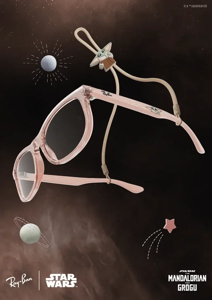 A play variation from the Ray-Ban x Star Wars: The Mandalorian and Grogu collaboration introduces translucent pastel-pink sunglasses accented with whimsical Grogu-themed detailing across the temples and accessories. Floating against a cosmic backdrop filled with illustrated planets and star graphics, the frame blends fashion-forward candy tones with the softer, more endearing side of the Star Wars universe. A Grogu-shaped charm attached to the eyewear cord reinforces the collectible nature of the release, transforming the sunglasses into a character-driven lifestyle accessory that merges luxury eyewear design with animated galactic nostalgia
