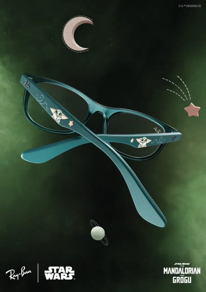 A darker, Grogu-inspired edition from the Ray-Ban x Star Wars: The Mandalorian and Grogu collection pairs glossy black frames with luminous green gradients that echo the character’s signature palette and mystical aura. Playful illustrations of Grogu decorate the temples alongside tiny stars and orbital doodles, giving the eyewear a collectible animated quality while maintaining Ray-Ban’s recognizable silhouette. Set against an emerald cosmic backdrop filled with floating planets and celestial graphics, the sunglasses balance childlike galactic charm with sleek contemporary styling, transforming the accessory into a wearable piece of Star Wars storytelling