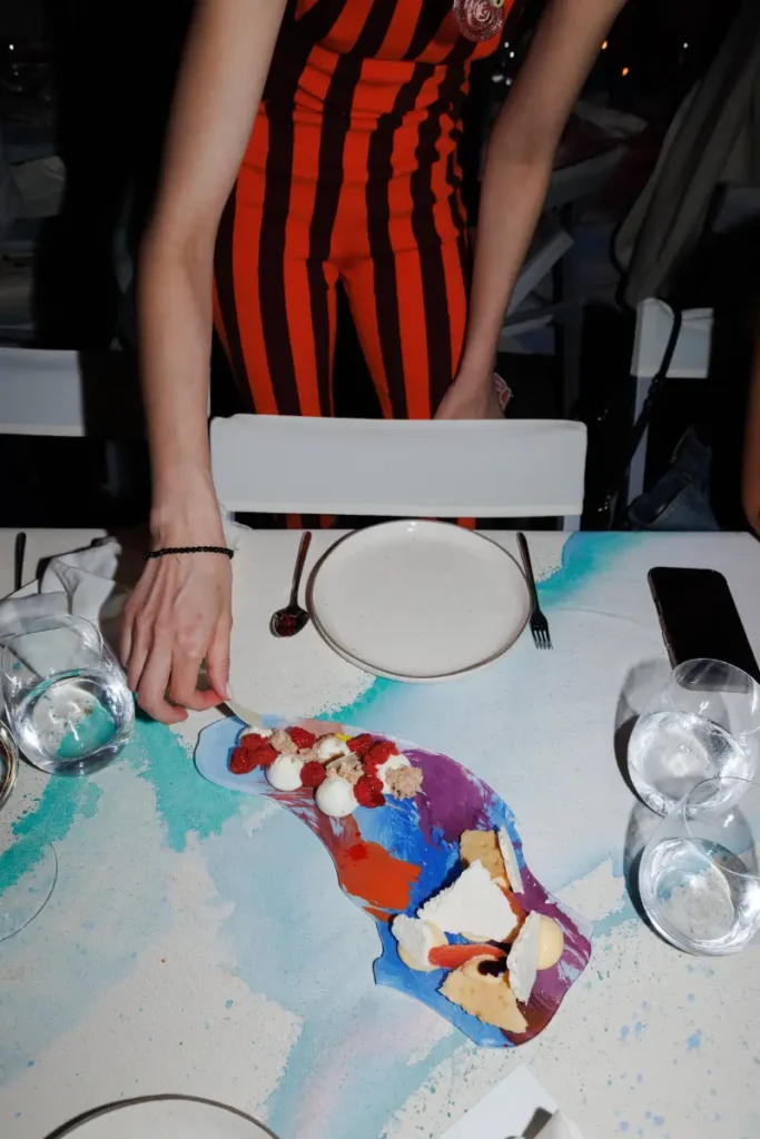 Artfully plated dessert presented on a hand-painted serving piece by Piro, combining vibrant colors, fresh berries, and sculptural presentation within the Obra installation environment