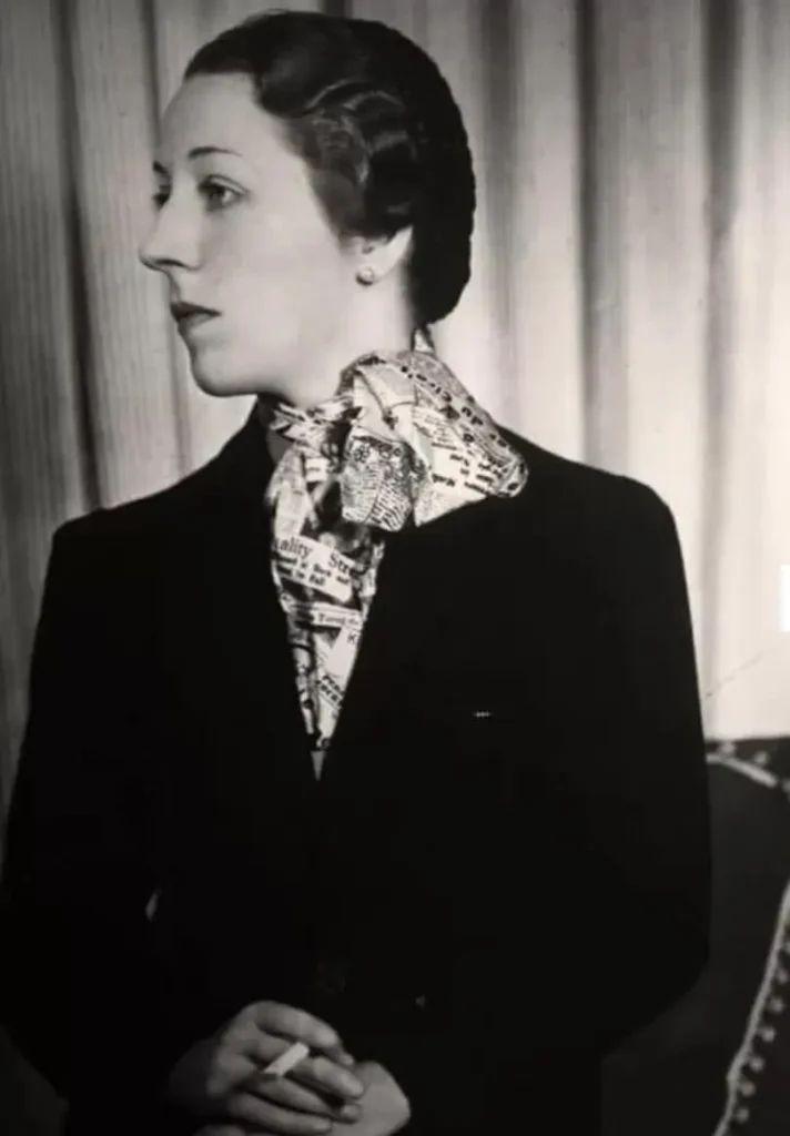 Close-up of monochrome newspaper-print textile featuring layered vintage-style clippings, headlines, and illustrations referencing Schiaparelli, with collage-like typography and archival imagery evoking early 20th-century press culture