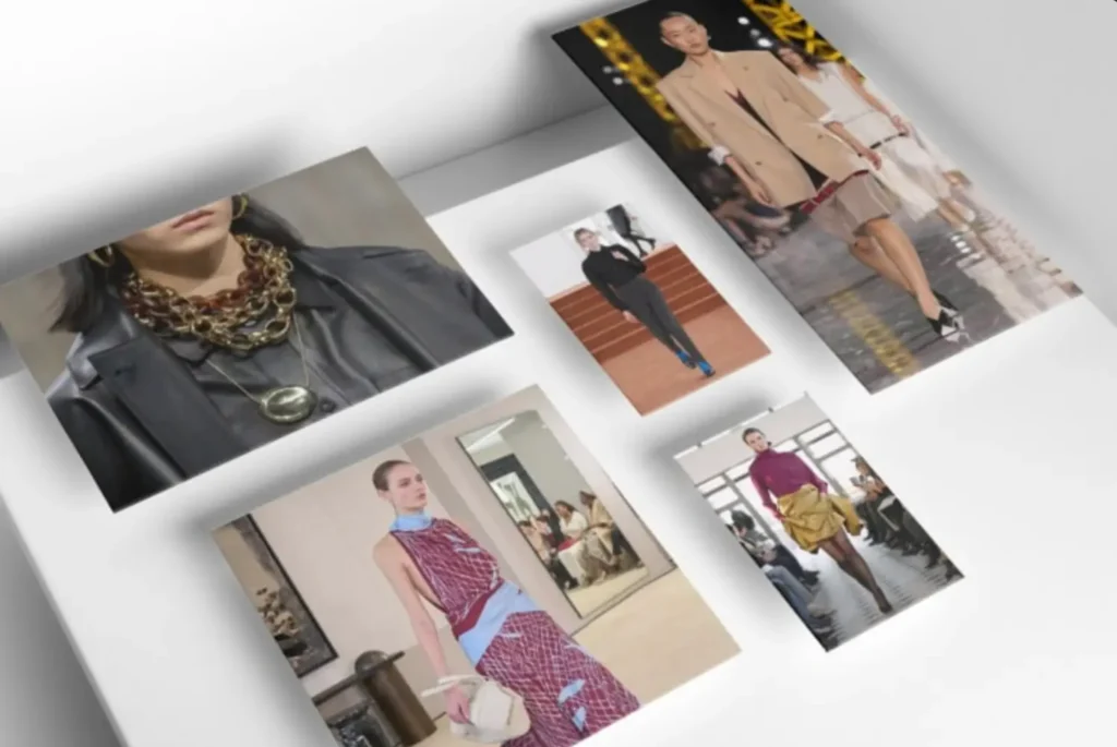 A curated collage of fashion imagery is laid out across a clean, white surface, each photograph slightly tilted, creating a sense of motion and editorial spontaneity rather than rigid alignment. The composition feels like a moodboard in progress—deliberate, but not overly fixed. In the upper left, a close-up focuses on layered chain necklaces in mixed metals, stacked densely over a black leather garment. The textures—polished metal against matte leather—create a tactile contrast, emphasizing weight and presence. The jewelry reads bold, almost armor-like, anchoring the composition with a sense of intensity. To the right, a runway image captures a model in a structured beige coat layered over a minimal look, walking under warm, golden lighting. The tailoring is clean, elongated, and precise, with a subtle tension between classic suiting and contemporary proportion. Behind it, another model follows in a softer, neutral palette, reinforcing a cohesive runway narrative. Centered between them, a smaller image shows a model in a pared-back black outfit—sharp, minimal, and grounded—punctuated by vivid blue footwear. The contrast feels intentional, drawing the eye downward and introducing a controlled disruption within an otherwise restrained look. At the bottom left, a model wears a patterned red dress with light blue accents, the fabric appearing fluid and slightly glossy. The silhouette is fitted yet relaxed, paired with a small, sculptural handbag that adds refinement. The setting—an interior space with mirrors and soft lighting—adds depth and reflection, subtly echoing the garment’s movement. On the lower right, another runway look introduces a richer palette: a deep magenta top paired with a voluminous golden skirt. The combination feels expressive and sculptural, with the skirt’s folds creating dimensionality as the model moves forward. Across the collage, the images collectively trace a dialogue between structure and fluidity, restraint and embellishment. Tailoring, texture, and color shift from frame to frame, but remain connected through a consistent editorial eye—one that values contrast, layering, and the quiet tension between classic codes and contemporary reinterpretation