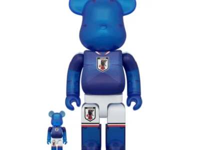 Product image of the official BE@RBRICK × Japan National Soccer Team (SAMURAI BLUE) 100% and 400% figure set featuring translucent blue bear figures wearing Japan’s national football kit with the JFA crest, navy gradient jersey detailing, and white shorts inspired by the team’s iconic match uniform