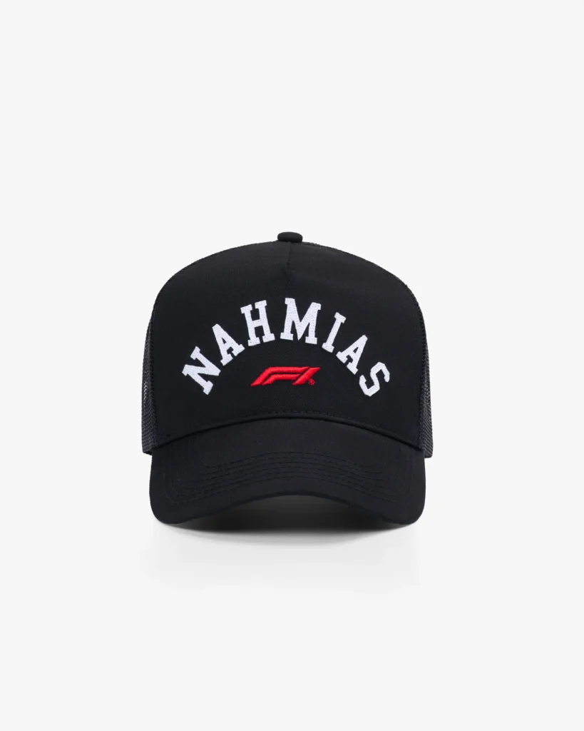 Black trucker-style cap with a structured front panel and curved brim, paired with breathable mesh backing for a classic, ventilated fit. The front features arched white “NAHMIAS” lettering, centered above a red Formula 1 logo, creating a bold, high-contrast focal point. A top button and tonal stitching complete the design, blending vintage motorsport influence with clean, everyday streetwear appeal