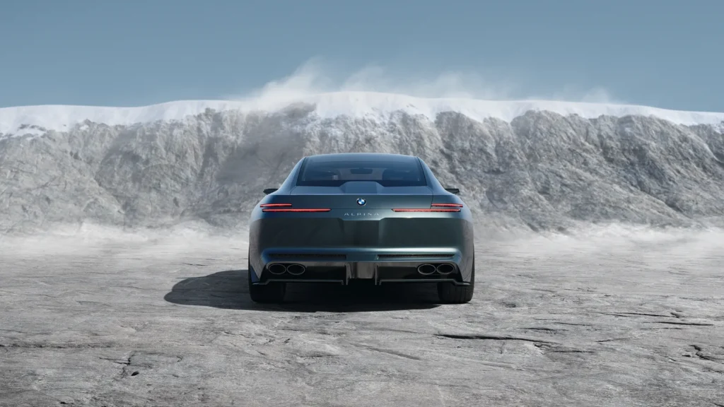 A perfectly centered rear view of the Vision BMW ALPINA emphasizes the concept’s disciplined symmetry and understated grand touring character against a stark Alpine quarry landscape. Ultra-slim horizontal taillights cut across the smooth rear fascia like illuminated precision lines, while discreet ALPINA lettering beneath the BMW roundel reinforces the marque’s restrained luxury philosophy. The lower diffuser integrates classic quad elliptical exhaust outlets, subtly preserving the brand’s V8 heritage beneath the otherwise minimalist architecture. Surrounded by windswept stone and snow-covered cliffs, the composition frames the coupe as a modern continental GT shaped by silence, proportion, and effortless long-distance performance rather than overt theatricality