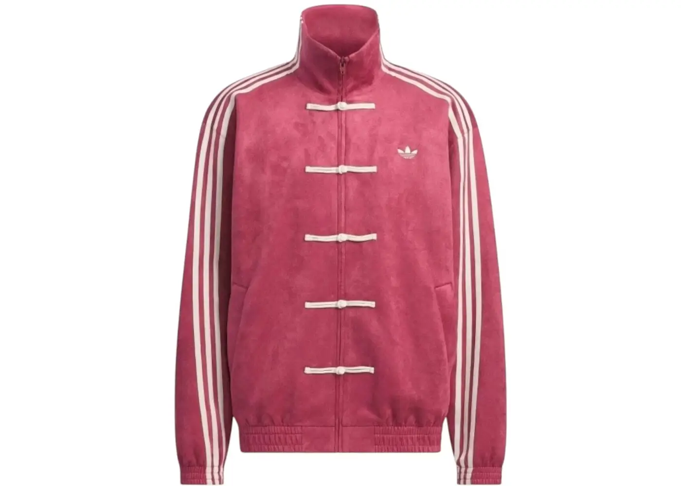 The adidas Originals CTT Chinese Track Top appears here in a vivid collegiate burgundy-pink colorway, bringing a brighter and more expressive energy to the heritage-inspired silhouette. The jacket features the signature Tangzhuang-style pankou frog-button closures, a structured high Mandarin collar, and adidas’ iconic Three Stripes running down the sleeves, merging traditional Chinese tailoring references with contemporary sportswear aesthetics. Its suede-like texture softens the bold color palette, while cream accents across the toggles, stripes, and Trefoil logo create balanced contrast throughout the design. The oversized fit and minimal construction allow the vibrant tone to remain the focal point, positioning the CTT as both a statement streetwear piece and a refined reinterpretation of classic athletic outerwear