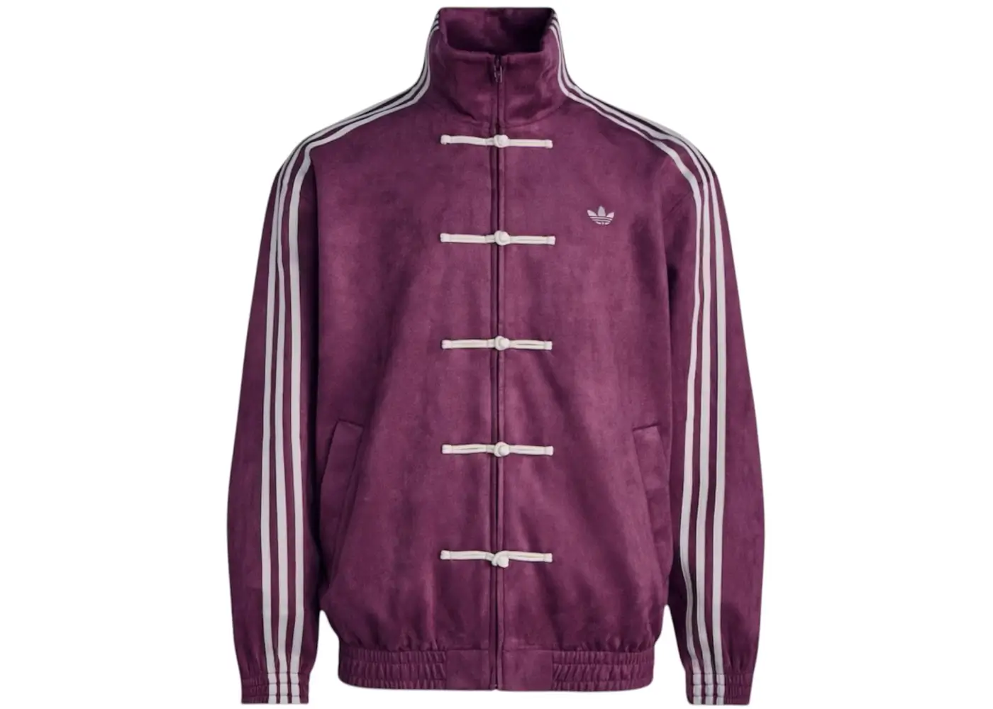 The adidas Originals CTT Chinese Track Top is presented here in a rich collegiate burgundy colorway, giving the heritage-inspired silhouette a more luxurious and fashion-forward presence. The jacket combines Tangzhuang-style pankou frog-button closures with adidas’ signature Three Stripes and a structured high Mandarin-style collar, merging traditional Chinese tailoring references with classic sportswear construction. The deep purple-red suede-like finish adds warmth and depth to the oversized silhouette, while the cream accents create subtle contrast throughout the garment. Minimal Trefoil branding and relaxed proportions reinforce the CTT’s understated aesthetic, positioning the piece between elevated streetwear, football-inspired outerwear, and contemporary East-meets-West fashion design