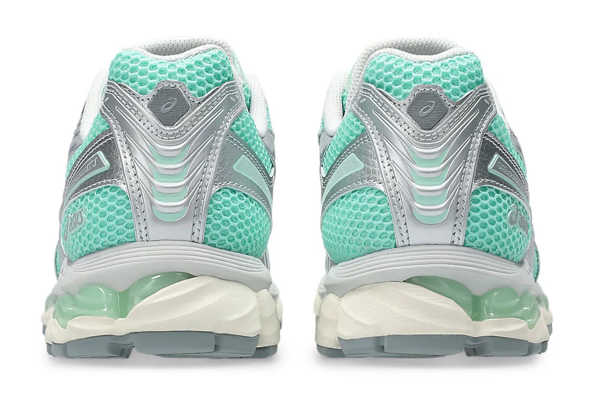 Rear heel view of the ASICS GEL-Kayano 12.1 showing sculpted silver heel counters, mint mesh heel panels, layered support geometry, and translucent GEL units above a cream-toned mid