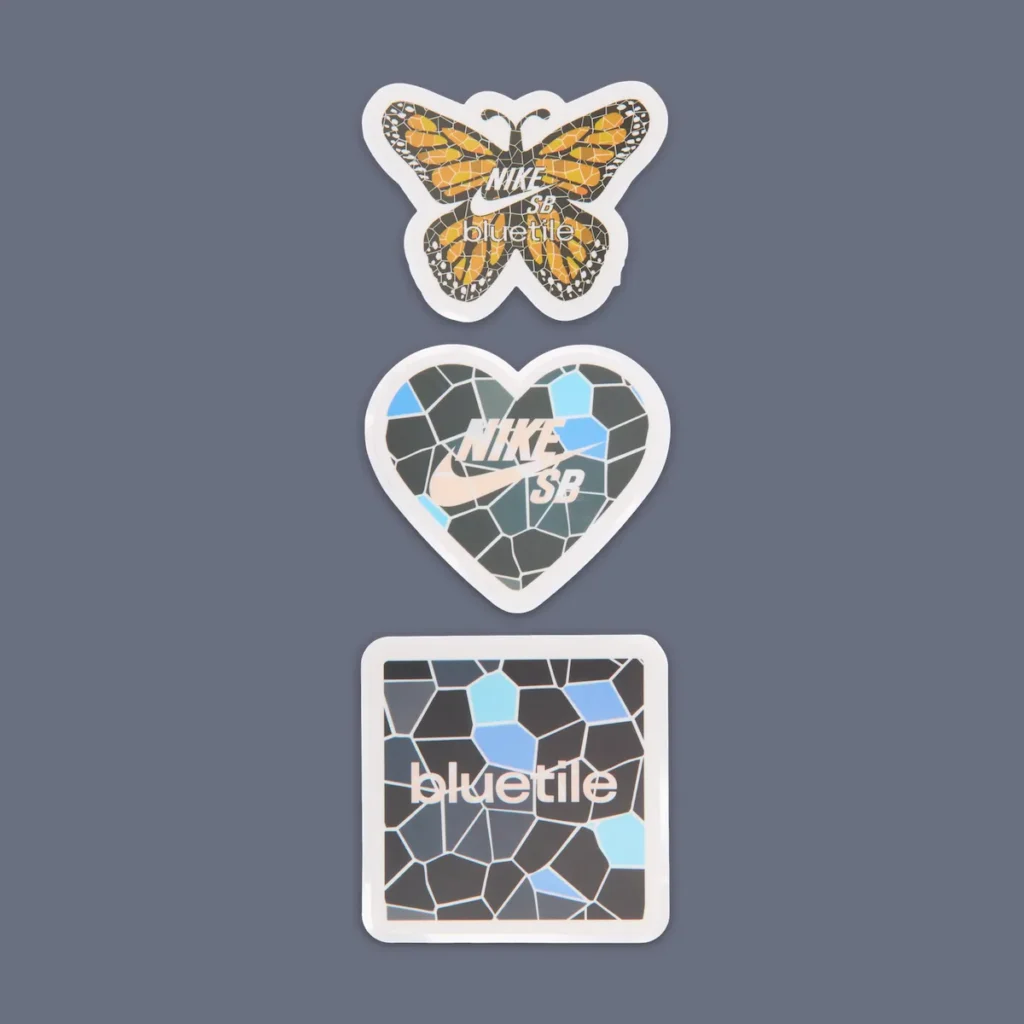 Sticker pack included with the Bluetile x Nike SB Dunk Low “Monarch Butterfly,” featuring butterfly-shaped, heart-shaped Nike SB, and square Bluetile graphics with mosaic-inspired blue and orange artwork