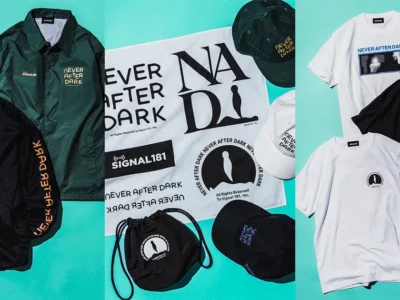 Flat-lay of the BEAMS x Never After Dark collection featuring graphic T-shirts, embroidered caps, drawstring bags, printed towels, and coach jackets in black, white, and dark green, showcasing horror-inspired artwork and SIGNAL181 branding against a turquoise background