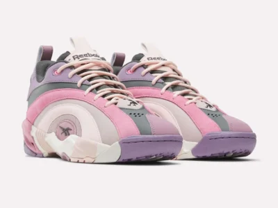 Front angled view of pastel Reebok basketball sneakers featuring pink suede overlays, lavender toe panels, cream midsoles, and charcoal accents with oversized sculpted tooling