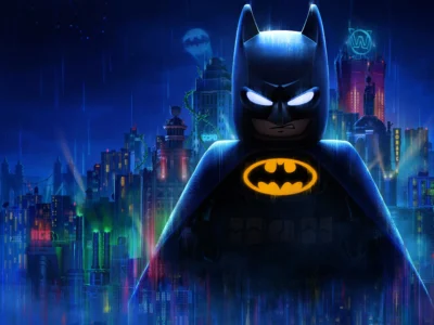 A towering LEGO Batman stands over a neon-lit Gotham City skyline at night, illuminated by rain, glowing billboards, and the iconic Bat-Signal in the distance