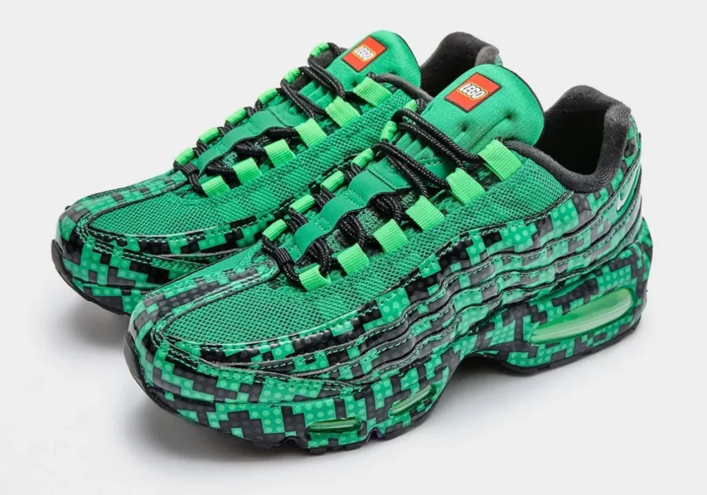 Three-quarter pair shot of the LEGO x Nike Air Max 95 “Lucky Green” displaying the complete collaboration design with textured LEGO-inspired graphics, bright green mesh uppers, black laces, LEGO tongue labels, and signature Air Max cushion