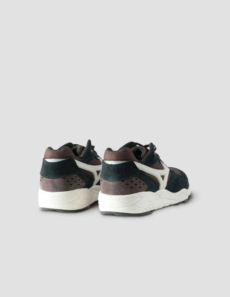 Rear view highlighting the structured heel counter, padded collar, and layered suede/mesh construction. Clean white midsole and subtle Mizuno detailing complete the minimalist profile