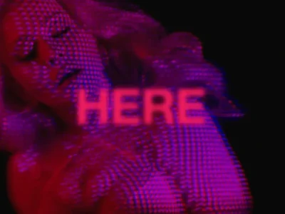 Stylized promotional image featuring a woman bathed in saturated red and violet lighting, partially obscured by a layered digital dot effect, with the word “HERE” glowing across the center against a dark background
