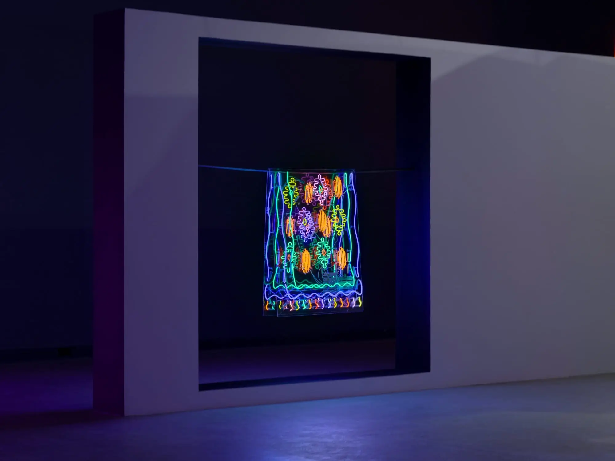 Illuminated textile-inspired installation by Roda Medhat featuring vibrant neon patterns suspended within a large architectural frame, transforming traditional Kurdish weaving motifs into glowing contemporary light art