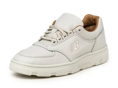Angled product shot of the New Balance Allerdale shoe in Vaporous Grey and Chipmunk, showcasing smooth off-white leather construction, tonal embroidered “NB” logo detailing, thick cream outsole tooling, and a warm tan inner lining on a minimalist studio background