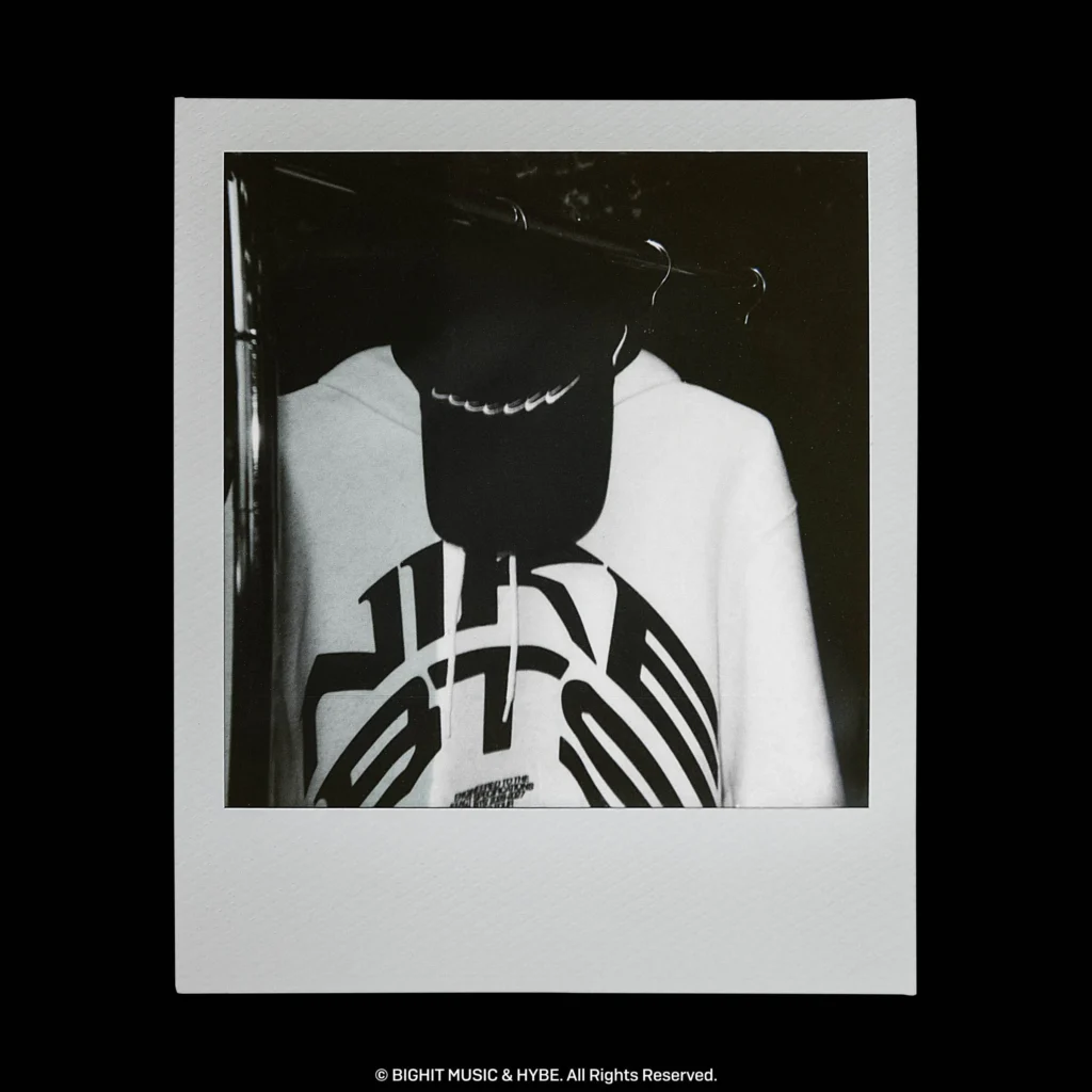 Detailed black-and-white view of a Nike BTS hoodie showcasing oversized front graphics and bold collab brand