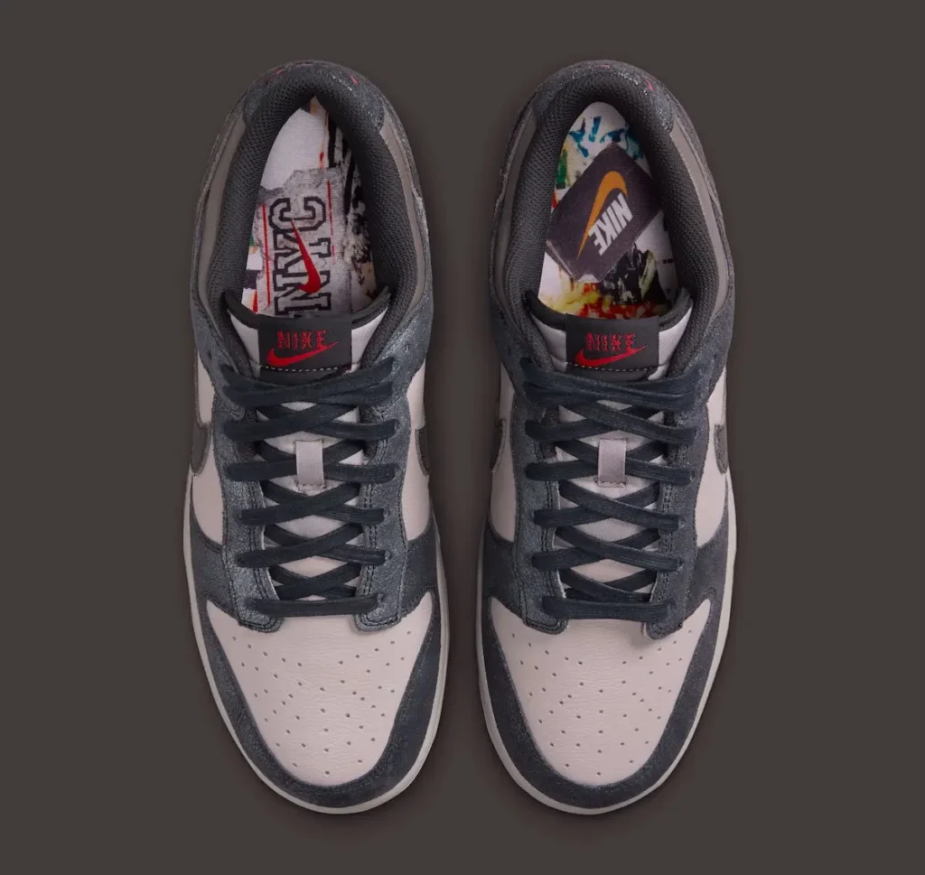 Top-down view of the Nike Dunk Low “CBGB” featuring distressed charcoal-grey overlays over off-white leather panels, waxed dark laces, and subtle red Nike tongue branding. Inside the shoe, graphic insoles reference the layered flyer-and-poster aesthetic associated with New York’s legendary CBGB venue, reinforcing the pair’s worn-in downtown punk identity