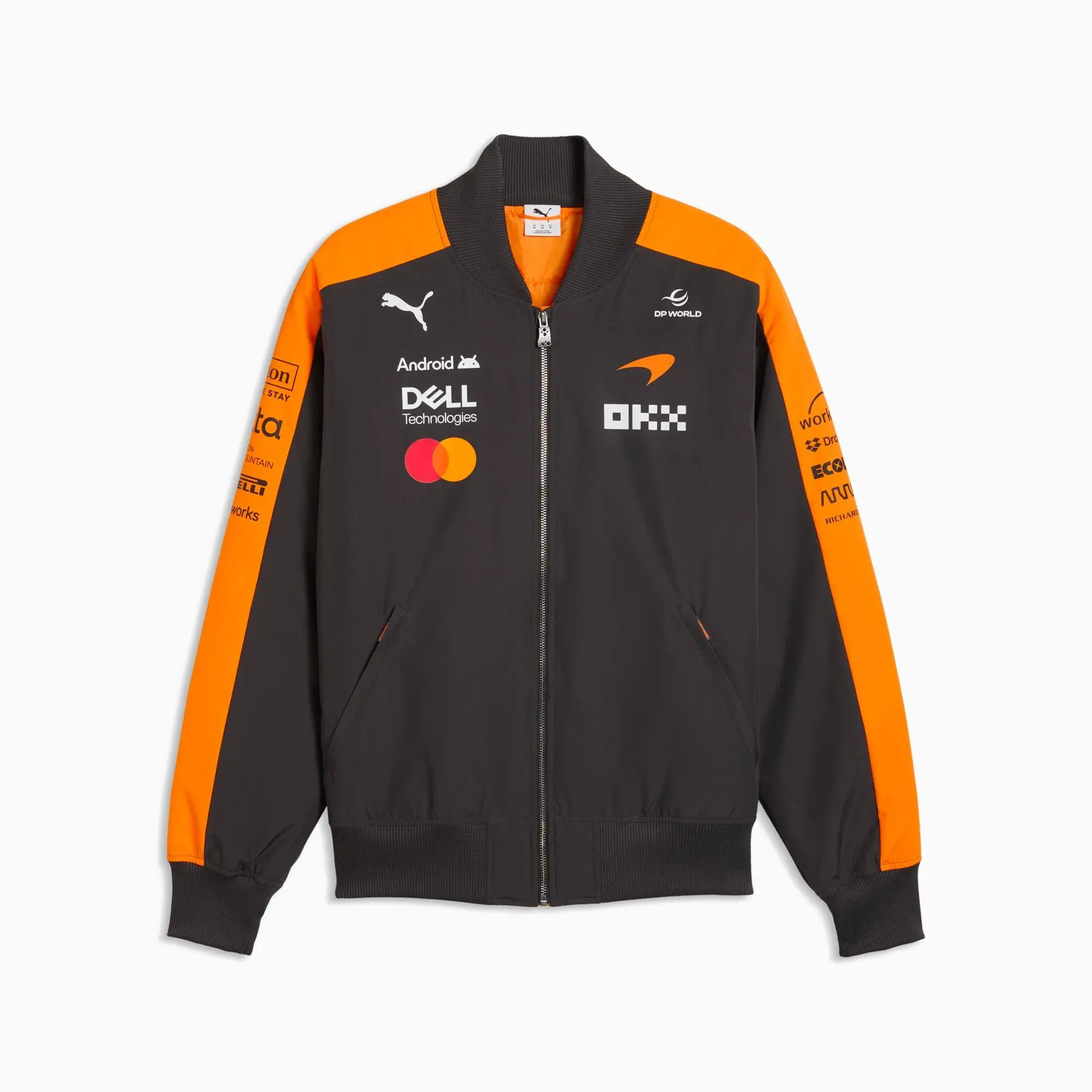 Black and papaya orange zip-up team jacket with a sporty, performance-driven silhouette and ribbed collar, cuffs, and hem. The design features bold orange paneling across the shoulders and sleeves, contrasting against the black base for a signature motorsport look. The chest is densely branded with sponsor logos, including Puma, Android, Dell Technologies, Mastercard, OKX, and DP World, alongside a McLaren emblem, reinforcing its official teamwear identity. Additional sponsor graphics run along the sleeves, enhancing the authentic race-team aesthetic. A full-length zipper and side pockets complete the piece, blending technical functionality with high-view Formula 1 styling
