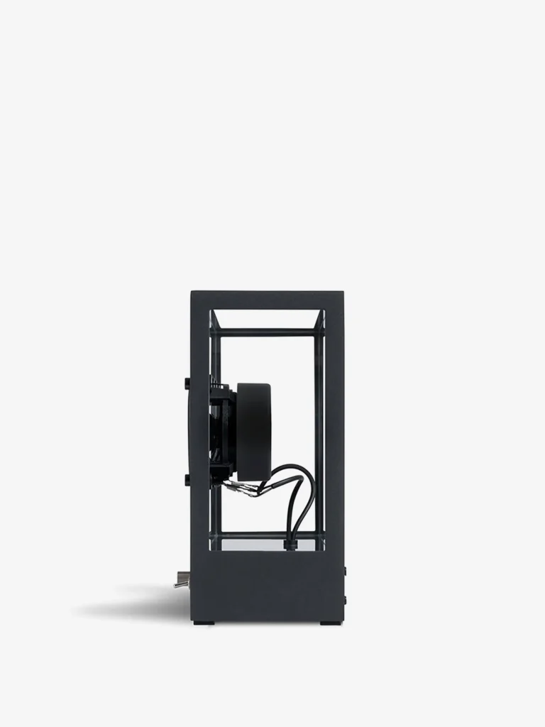 Side profile view of the Transparent Sound Small Speaker in Black featuring an exposed driver unit, open-frame aluminum structure, visible wiring, and minimalist Scandinavian industrial design against a light gray backdrop