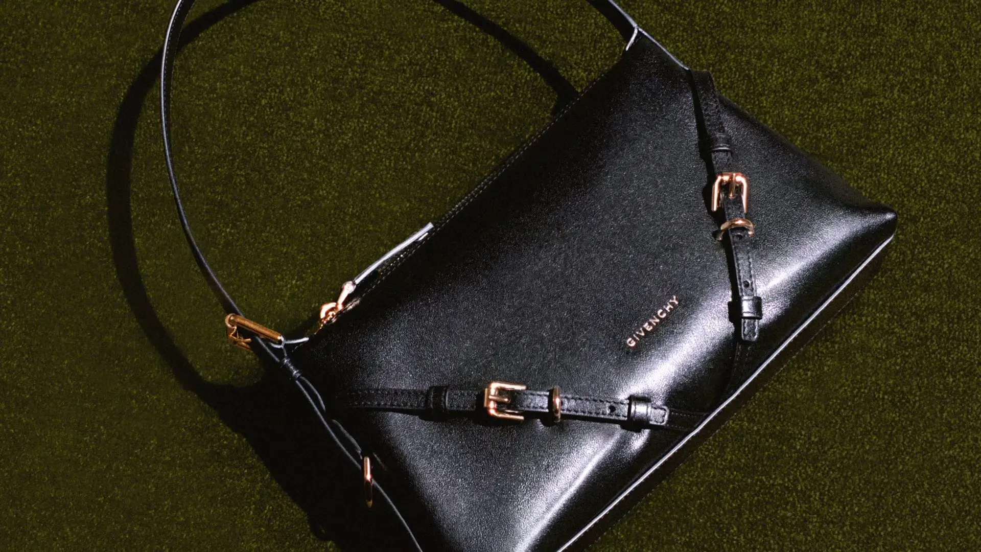 The black Givenchy Voyou Bucket presents the silhouette in its most refined and dramatic form, combining glossy calfskin leather with silver-tone hardware and exaggerated slouch. The oversized structure folds naturally into soft, sculptural drapes that emphasize movement and fluidity rather than rigid construction. Set against classical stone architecture and open sky, the bag feels cinematic and quietly imposing, balancing Parisian elegance with biker-inspired attitude. Elongated straps, subtle buckle detailing, and minimal branding reinforce the Voyou line’s understated approach to contemporary luxury, where texture, proportion, and silhouette communicate more powerfully than overt logos
