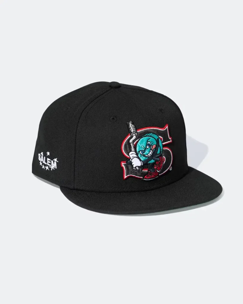 A black fitted cap from the Supreme x SALEM Spring/Summer 2026 collaboration featuring embroidered co-branded graphics across the crown and side panel. The design combines a mischievous cartoon mascot, varsity-style “S” insignia, and SALEM star branding, translating underground rave aesthetics and chaotic Americana references into a sharp sportswear accessory silhouette