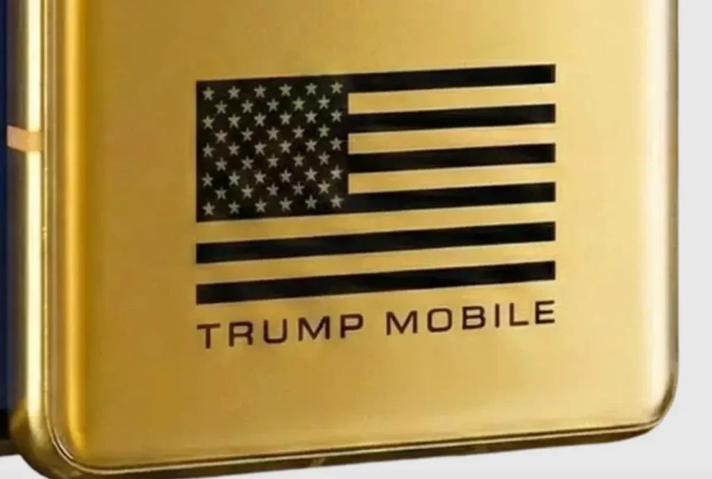 Close-up detail of the gold Trump Mobile T1 Phone showcasing the black American flag graphic, metallic brushed finish, and bold Trump Mobile branding engraved across the rear panel