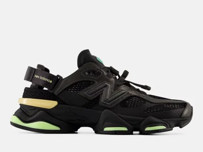 Angled front view of the New Balance U9060Sv1 sneaker-sandal in black highlighting its futuristic layered upper, oversized proportions, quick-lace system, and lime-green cushioning accents