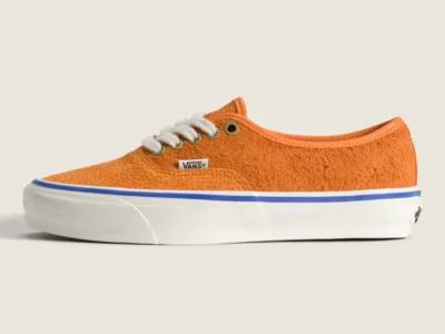 Orange Vans OTW Authentic 44 Siped Vibram sneaker in profile view featuring shaggy suede construction, textured amphibian-inspired overlays, white laces, and a blue foxing stripe above the white mid