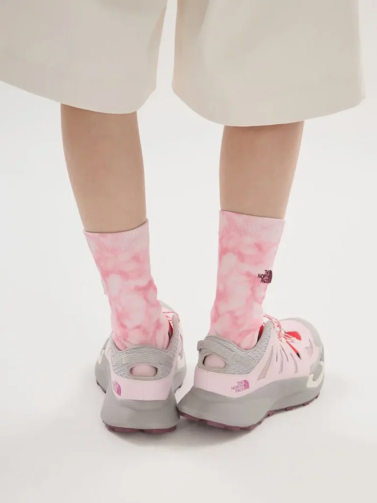: Rear angle of The North Face VECTIV Breeze sneakers paired with pink tie-dye socks, highlighting heel structure and trail outsole