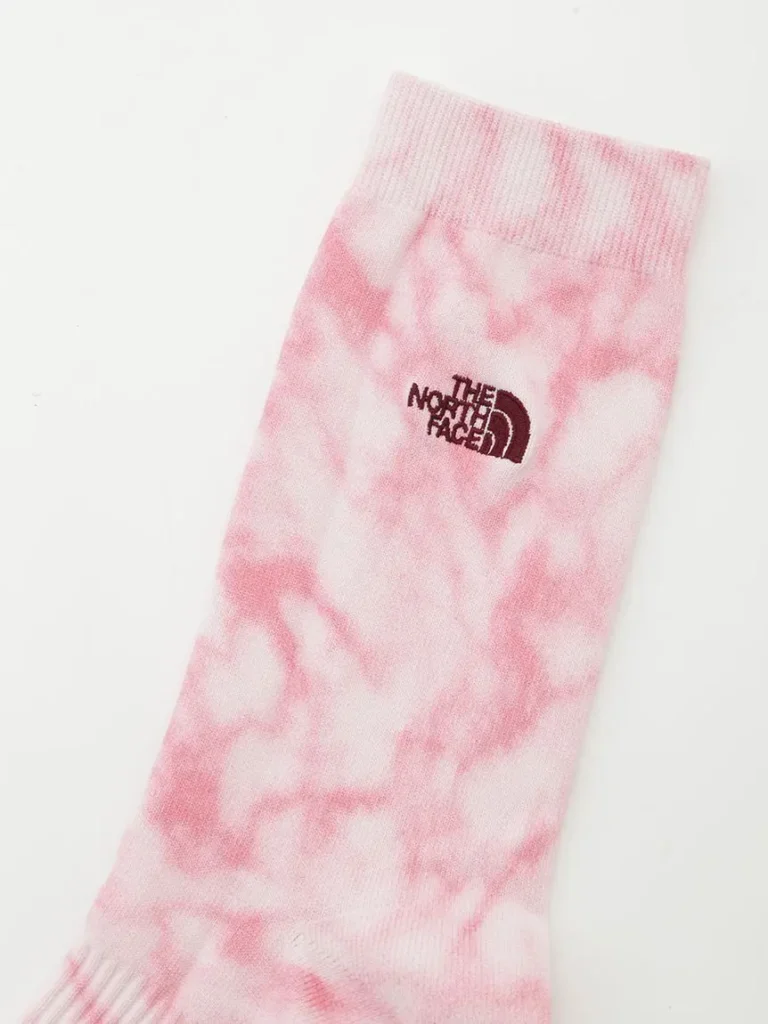 Product image of The North Face tie-dye crew socks in pink and white featuring subtle marbled graphics and outdoor-inspired style