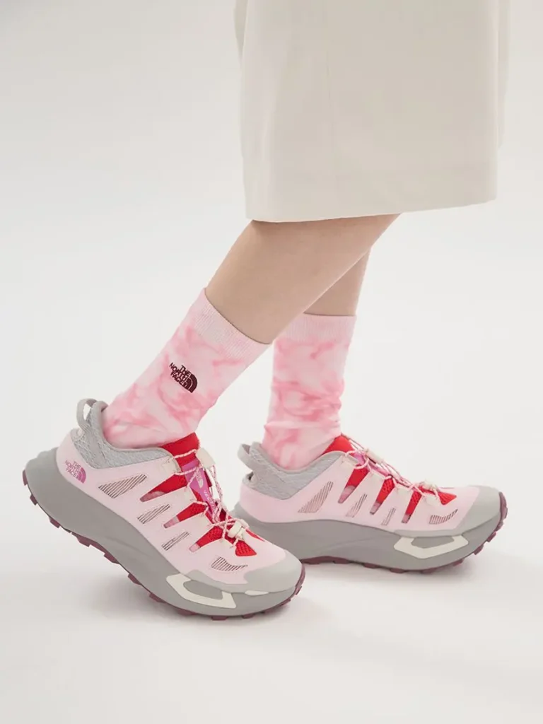 Side profile of The North Face VECTIV Breeze highlighting lightweight construction, pink overlays, coral mesh panels, and cushioned grey mid