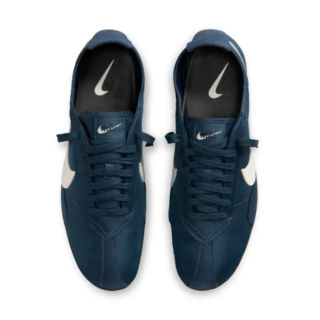Top-down view of the shoe pair featuring navy nylon uppers, matching flat laces, black insoles with white Nike branding, and vintage-inspired tongue label