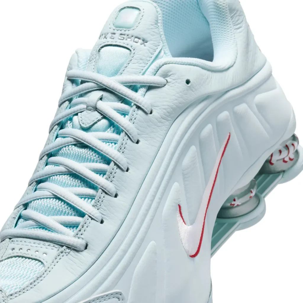 Close-up of the Nike Shox R4 upper highlighting textured leather overlays, mesh tongue construction, and embroidered Swoosh brand