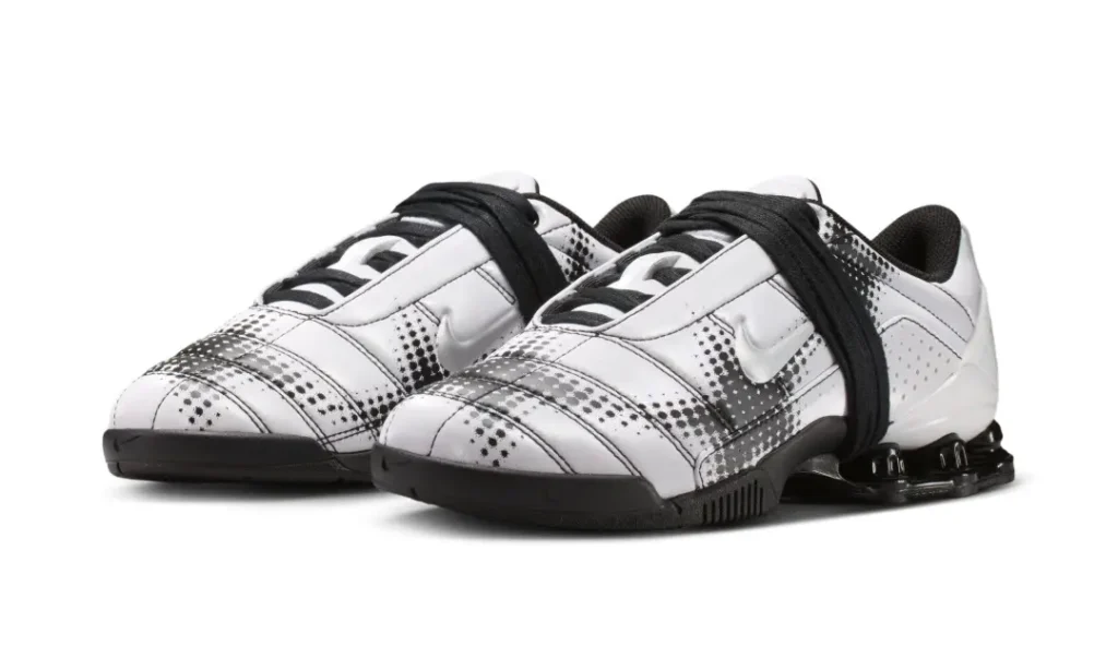 Angled product shot of the white sneaker pair highlighting the contrast between the crisp white upper and black pixelated graphic