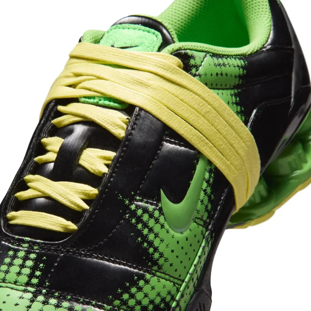 Close-up of the green colorway focusing on oversized pale-yellow laces, tonal green Swoosh, and pixelated plaid graphics across the upper