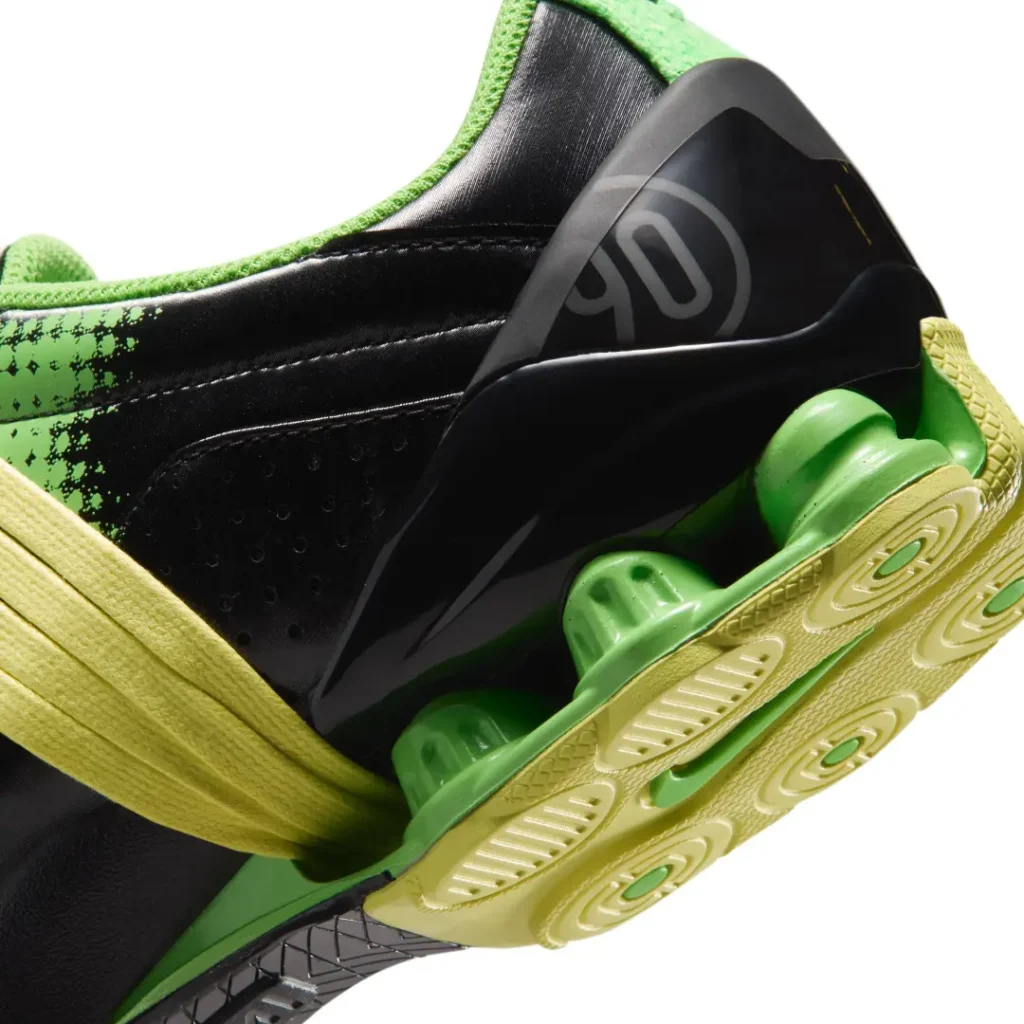 Detailed heel close-up of the green shoe highlighting the sculpted heel counter, translucent green Shox cushioning, and textured outsole